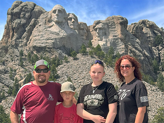 Jeff Dumas, a concrete contractor in Utah, stands in front of Mt. Rushmore with his family at the concrete foundations association summer conference.