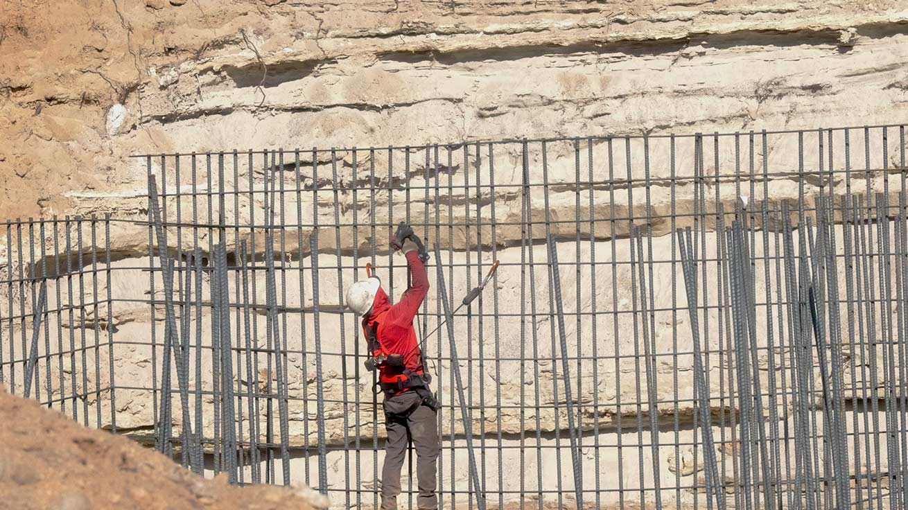 Worker tying #7 rebar for custom 20-foot foundation wall by Utah concrete contractor in Sandy