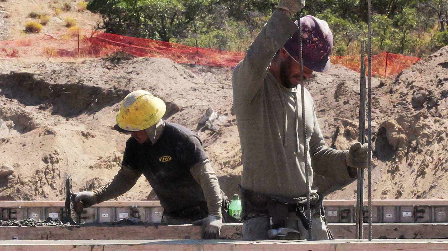 Concrete foundation contractors placing rebar and preparing forms for a residential foundation in the Pepperwood Community in Sandy Utah